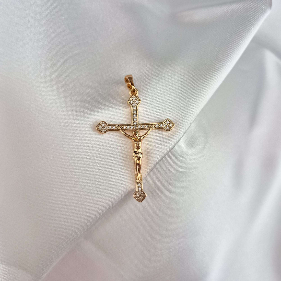 Cirkoniem rotāts krustiņš ar 18K zelta pārklājumu uz balta atlasa krokām